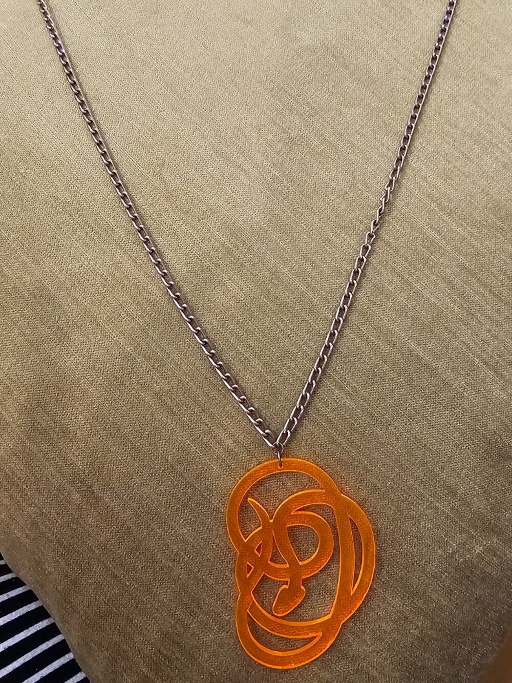 Finish off your summer look with this one of a kind orange plastic snake pendant